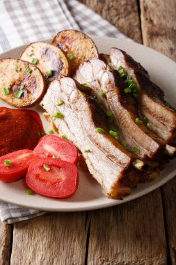 Kızarmış domuz eti plaka yakın çekim üzerinde fırında patates ile. Vert