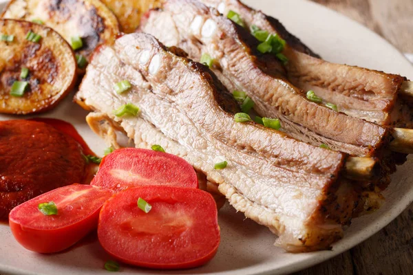 Kızarmış domuz kaburga sos ve domates ile kapatın. Yatay