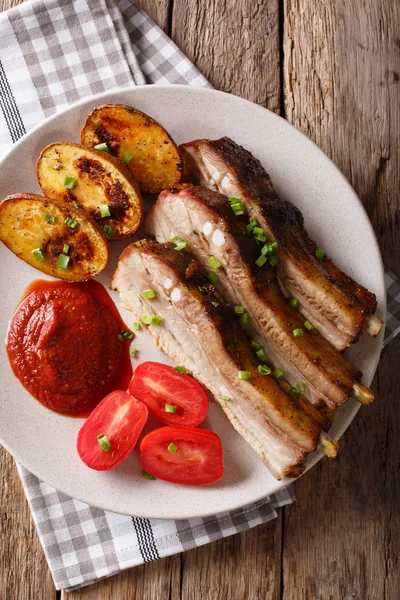 Baked pork brisket with potatoes and sauce close up. vertical to — Stock Photo, Image