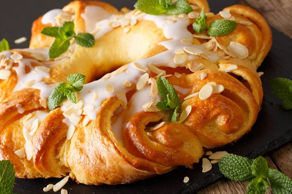 Hermosa cocción: brioche con glaseado de azúcar y almendras de cerca . — Foto de Stock