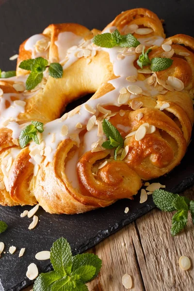 Festive sweet brioche with glaze and almonds close-up. vertical — Stock Photo, Image