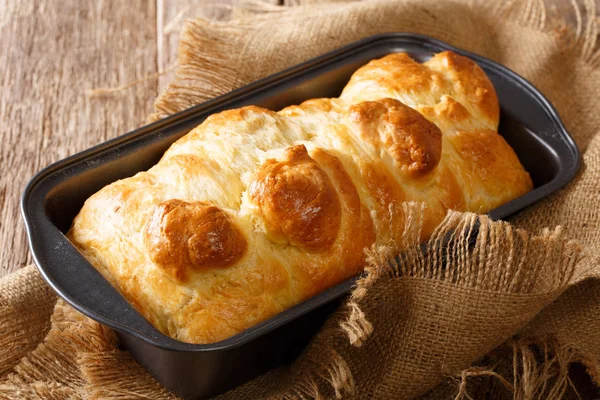 Pan brioche aromático caliente en un plato para hornear de cerca. horizontal —  Fotos de Stock