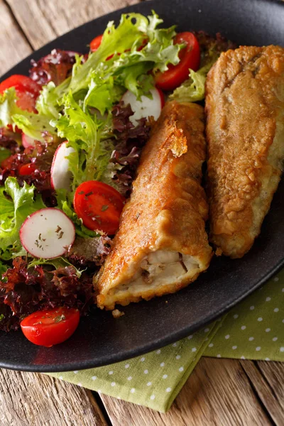 Σαλάτα από φρέσκα λαχανικά και τηγανητό ψάρι μπακαλιάρος close-up. κάθετη — Φωτογραφία Αρχείου