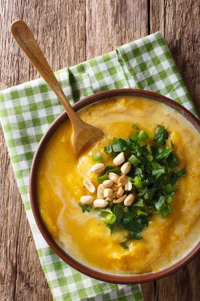 Thai-Kürbissuppe mit Kokosmilch und Erdnüssen in Nahaufnahme. vertikal — Stockfoto