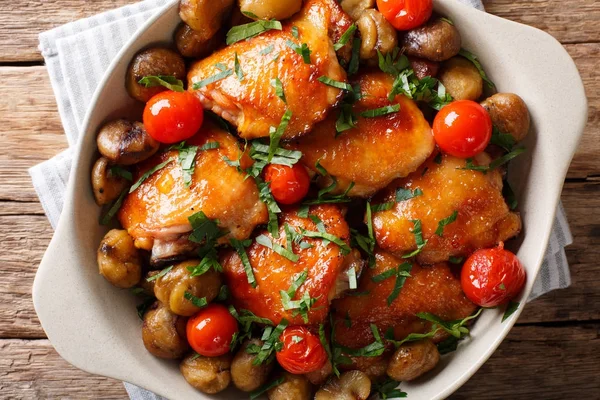 Chicken thighs roasted with chestnuts and tomatoes close-up in a — Stock Photo, Image