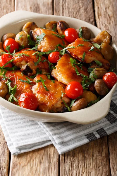 Pieces of chicken fried with chestnuts and tomatoes close-up in — Stock Photo, Image