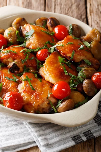 Chicken thighs roasted with chestnuts and tomatoes close-up in a — Stock Photo, Image