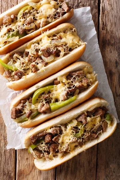 Philly cheese steak sandwich served on parchment paper close-up.