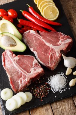 Sebze ve baharat yakın çekim ile ham t-bone biftek. dikey