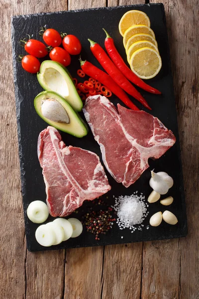 Bio crue t-bone steak de boeuf avec des ingrédients close-up. Vertica — Photo