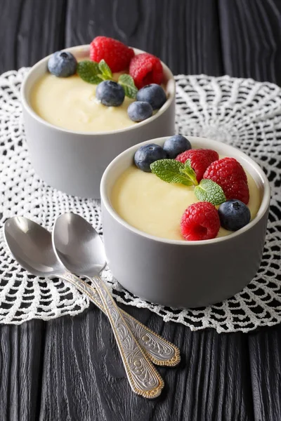 Healthy food: vanilla pudding with berries close-up. vertical — Stock Photo, Image