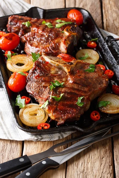 Tasty barbecue: T Bone steak with tomato, chili and onions on th — Stock Photo, Image