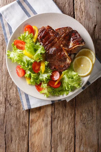 Leckeres gegrilltes T-Bone Steak mit frischem Gemüse und Zitronensaft — Stockfoto