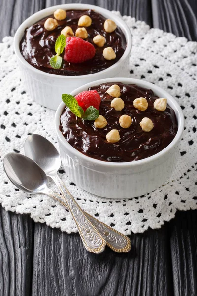 Шоколадный пудинг украшен фундуком, мятой и малиной — стоковое фото