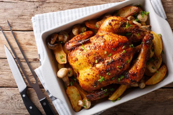 Frango assado inteiro com cogumelos e batatas close-up em um ba — Fotografia de Stock