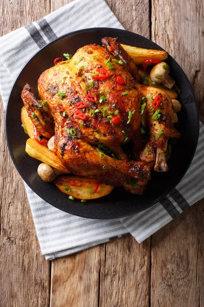 Frango inteiro cozido no forno com cogumelos e batatas close-up em um pl — Fotografia de Stock