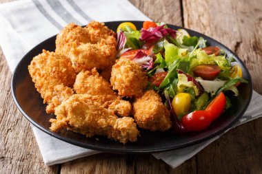 Kızarmış tavuk kanadı ekmek kırıntıları ve taze sebze salatası clo