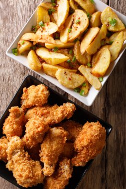 Kavrulmuş Tavuk kanatları ve patates dilimleri kapatın. Dikey üst v