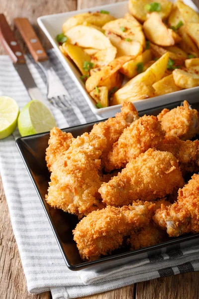 Fried chicken wings in bread crumbs and potato wedges close up. — Stock Photo, Image