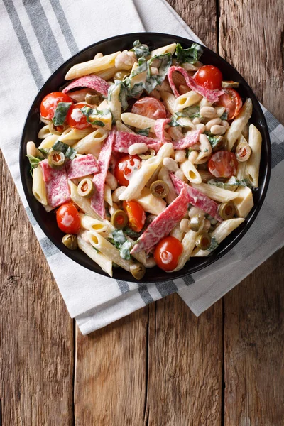 Pasta penne with salami, olives, spinach, tomatoes and beans clo — Stock Photo, Image