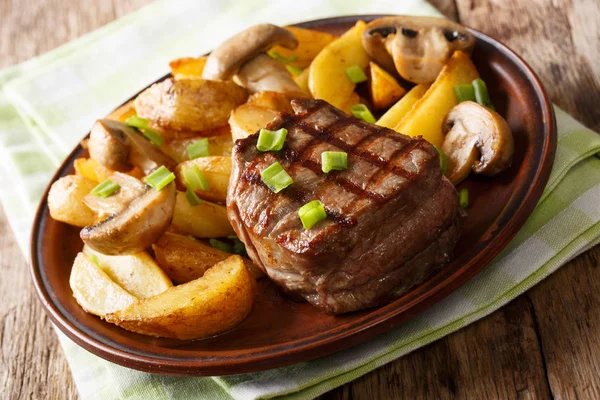 Filete mignon com batatas fritas e cogumelos close-up em um pl — Fotografia de Stock