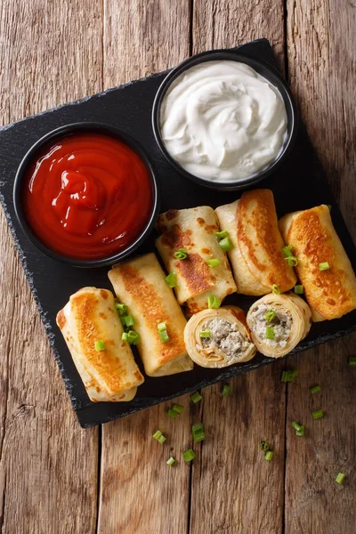 Crepes stuffed with chicken and mushrooms close-up and tomato sa — Stock Photo, Image