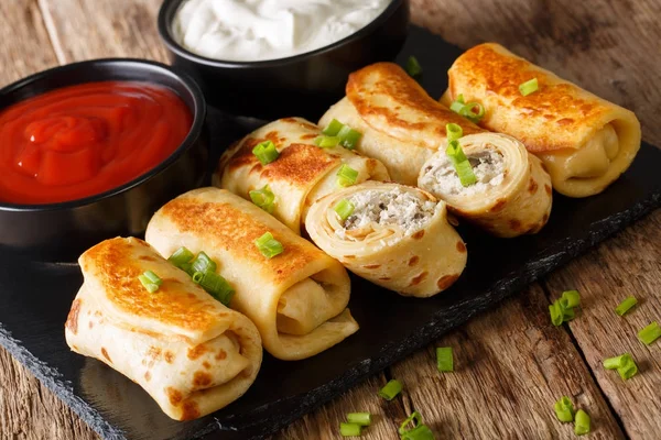 Pancakes rolls stuffed with chicken and mushrooms close-up and t