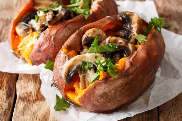 Baked whole sweet potato with mushrooms and cheese close-up. hor — Stock Photo, Image