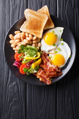 Lezzetli kızarmış yumurta, pastırma, fasulye, kızarmış ekmek ve taze sebze sa