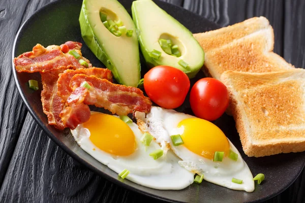 Heerlijk ontbijt van eieren met krokant spek, avocado, toast een — Stockfoto