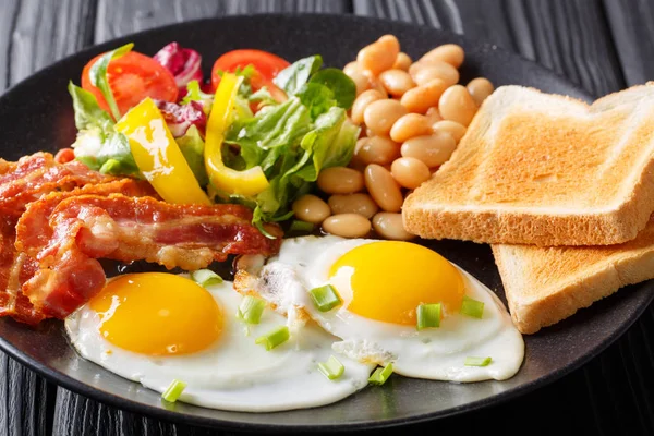 Delicious fried eggs, bacon, beans, toast and fresh vegetable sa — Stock Photo, Image