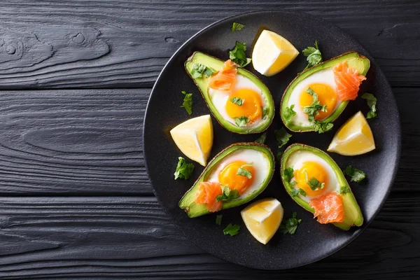 Aguacate al horno con huevo, salmón ahumado y verduras de cerca en una p — Foto de Stock