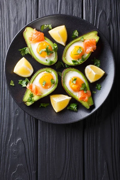 Aguacate al horno con huevo, salmón ahumado y verduras de cerca en una p — Foto de Stock