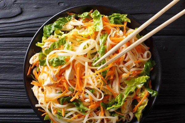 Asian food: chicken salad with rice noodles, carrots and greens — Stock Photo, Image