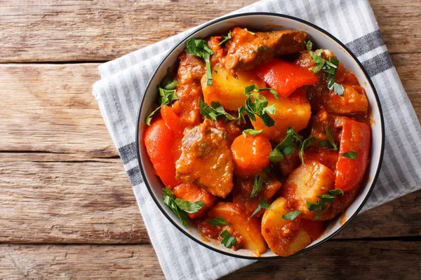 La carne cocida con hortalizas en la salsa picante en la escudilla a la mesa . — Foto de Stock