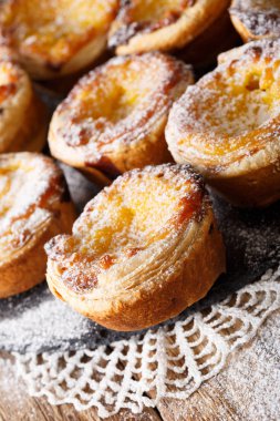 Portekizce tatlı: Pastel de nata ile pudra şekeri yakın çekim.