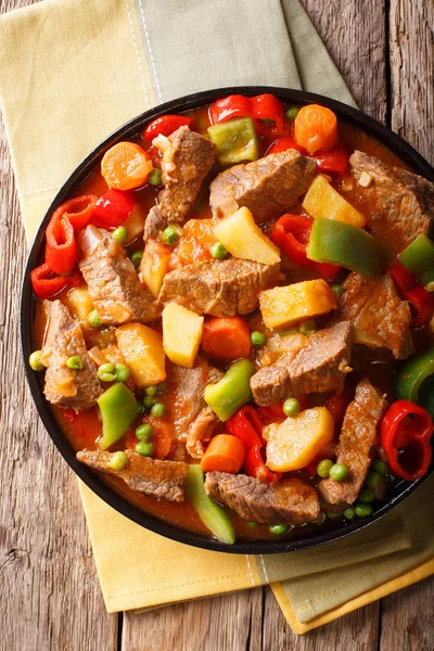 Carne de bovino cozida lentamente com batatas, pimentas, ervilhas, tomates e carr — Fotografia de Stock