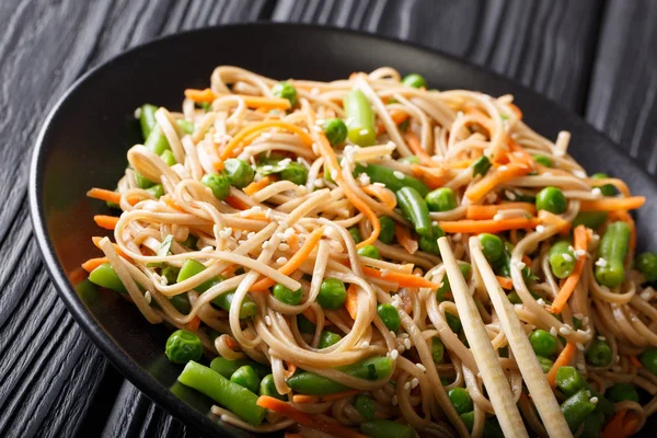 Buckwheat Soba con verduras y sésamo de cerca en un plato. h — Foto de Stock