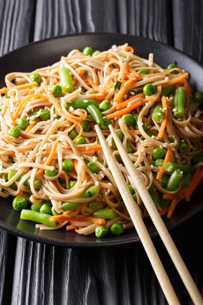 La ensalada caliente de la soba con hortalizas y el sésamo el primer plano en la plancha — Foto de Stock