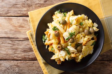 Kızarmış patates, soğan, yumurta ve zeytin üzerinde bir pla ile cod rendelenmiş