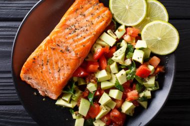 Salata avokado ve domates closeup o gelen pişmiş somon fileto