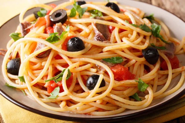 Pasta Alla Puttanesca with anchovies and black olives macro. hor — Stock Photo, Image