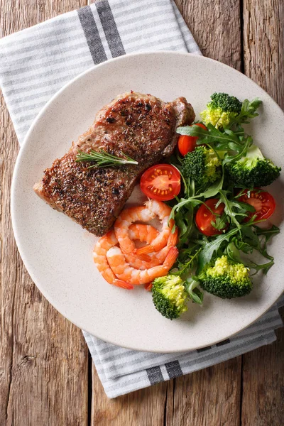 Delicious grilled beef steak with prawns and broccoli, tomatoes,