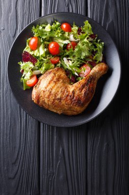 Kızarmış tavuk budu ile taze sebze salatası yakın bir plaka üzerinde çekim