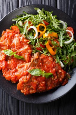 Sığır eti biftek pizzaiola sos ve taze salata yakın çekim. Vertic