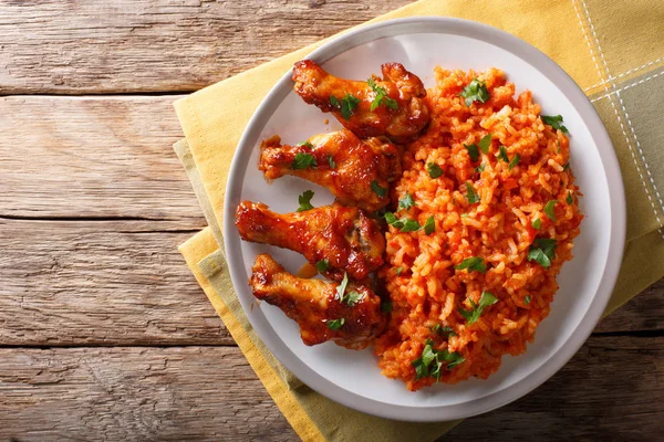 Fiesta de comida nigeriana: Jollof arroz con alas de pollo frito cerrar - — Foto de Stock
