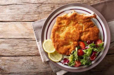 veal Milanese with lemon and fresh salad of tomatoes and lettuce clipart