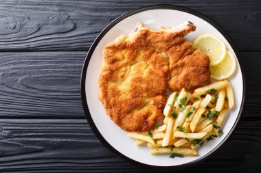 Traditional Italian veal Milanese with lemon and French fries cl clipart