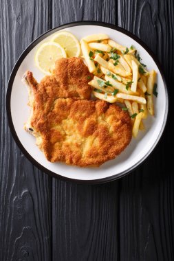 Traditional Italian veal Milanese with lemon and French fries cl clipart