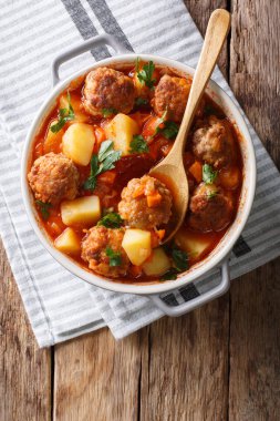 Hot stew meatball soup with vegetables in tomato sauce closeup i clipart